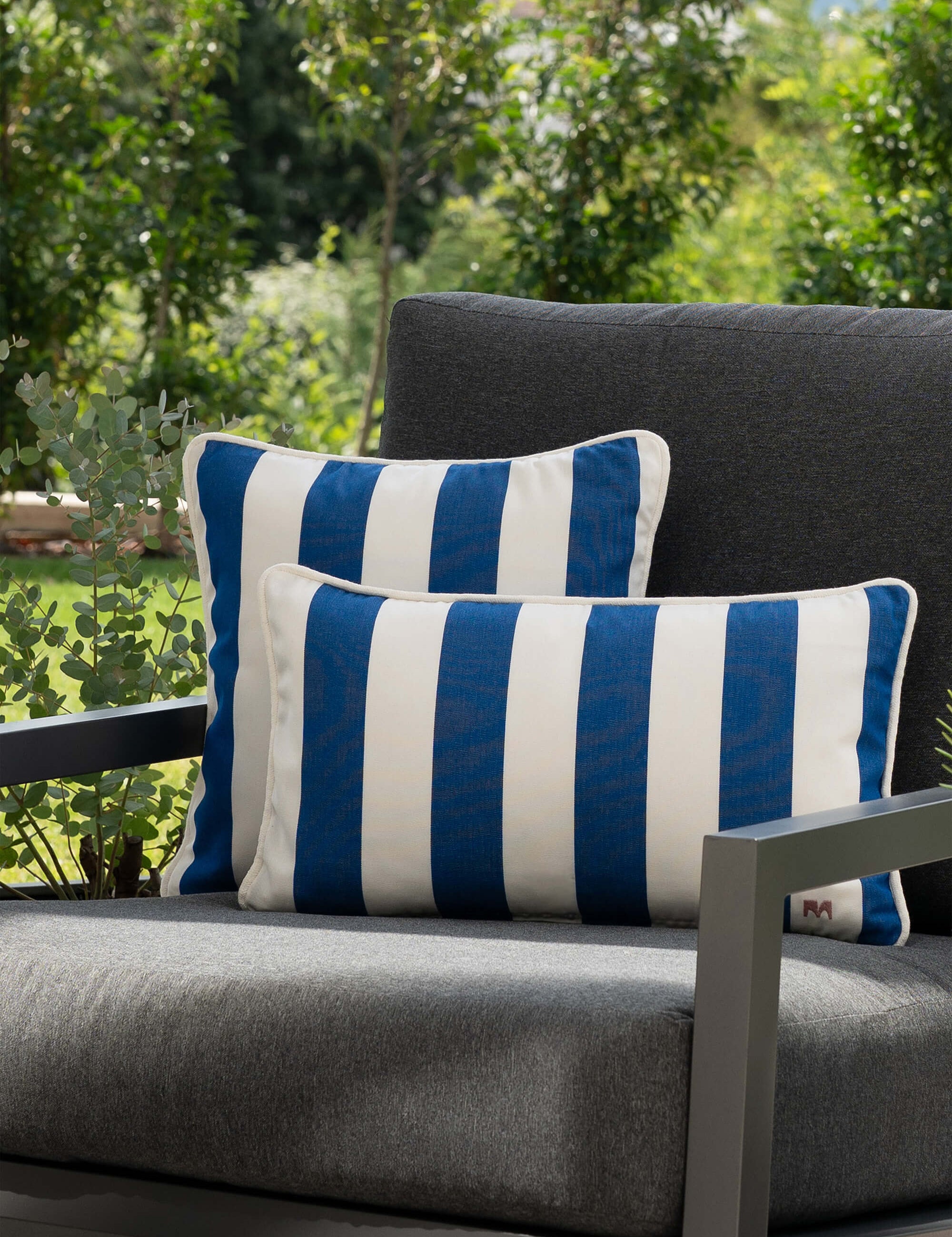 another mondaen Outdoor Kissen Classic Striped Blue auf moderner Gartenlounge – gestreifte Designkissen für Terrasse und Garten