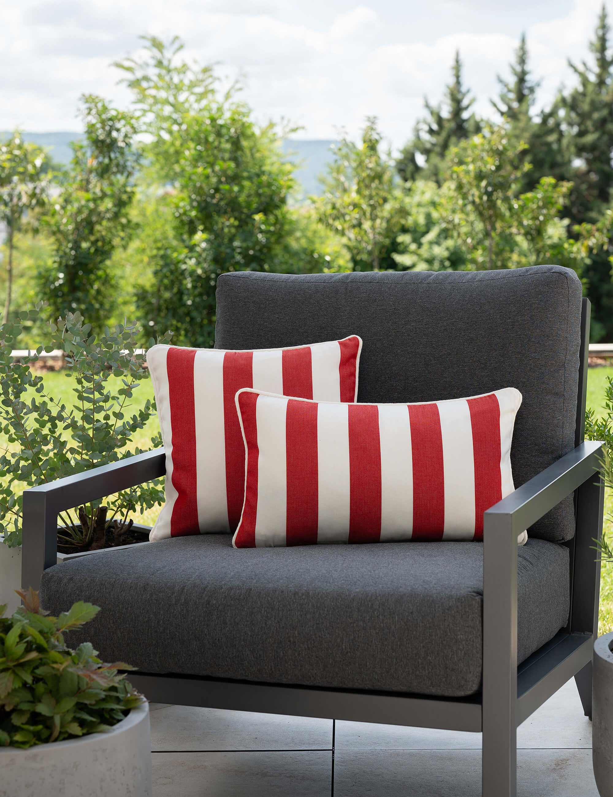 another mondaen Outdoor Kissen Classic Striped red auf moderner Gartenlounge – gestreifte Designkissen für Terrasse und Garten