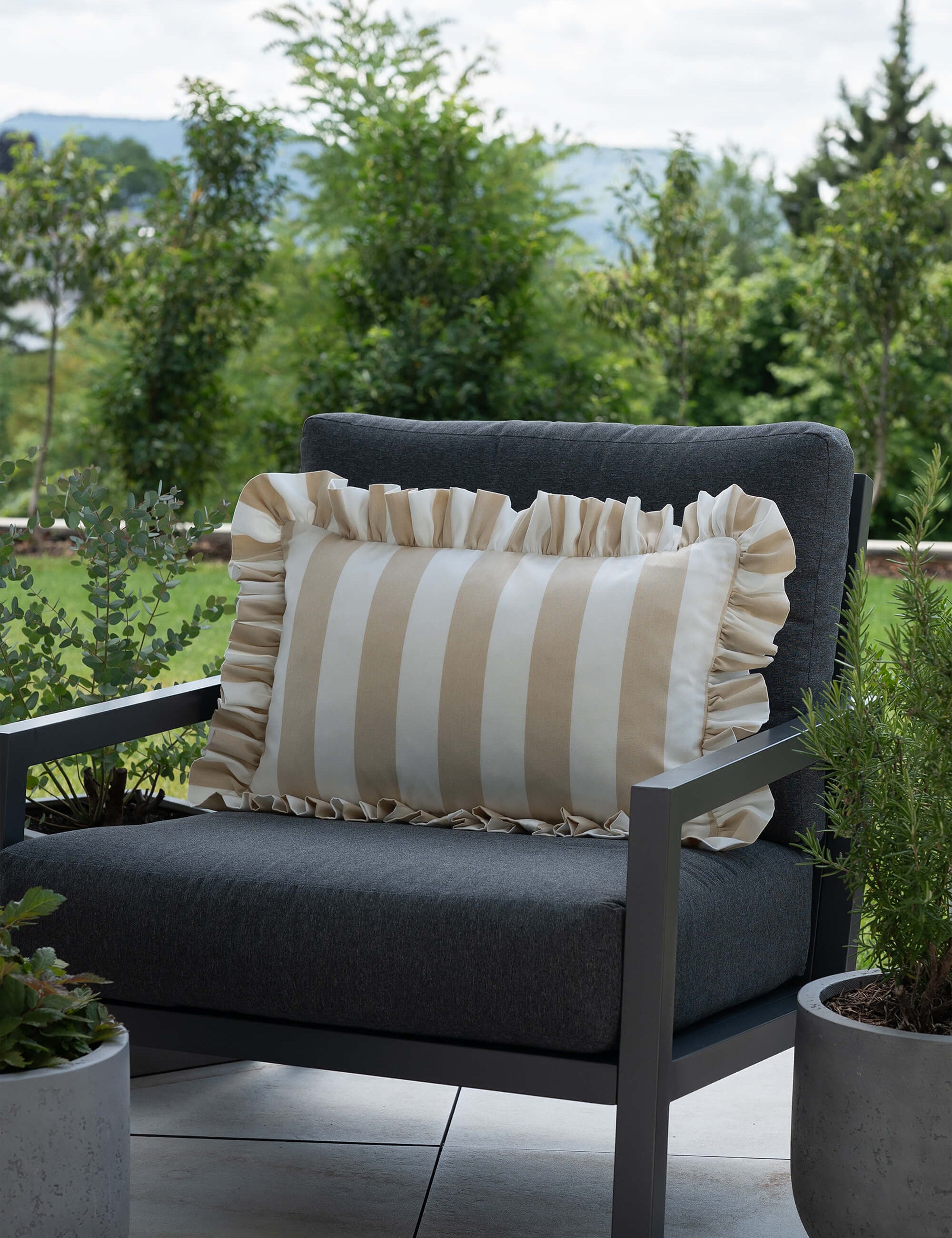 another mondaen Outdoor Kissen Ruffled Charm Erich in Beige auf Gartenlounge – beige-weiß gestreifte Designkissen für Terrasse und Garten aus der VACANCES Outdoor Kollektion