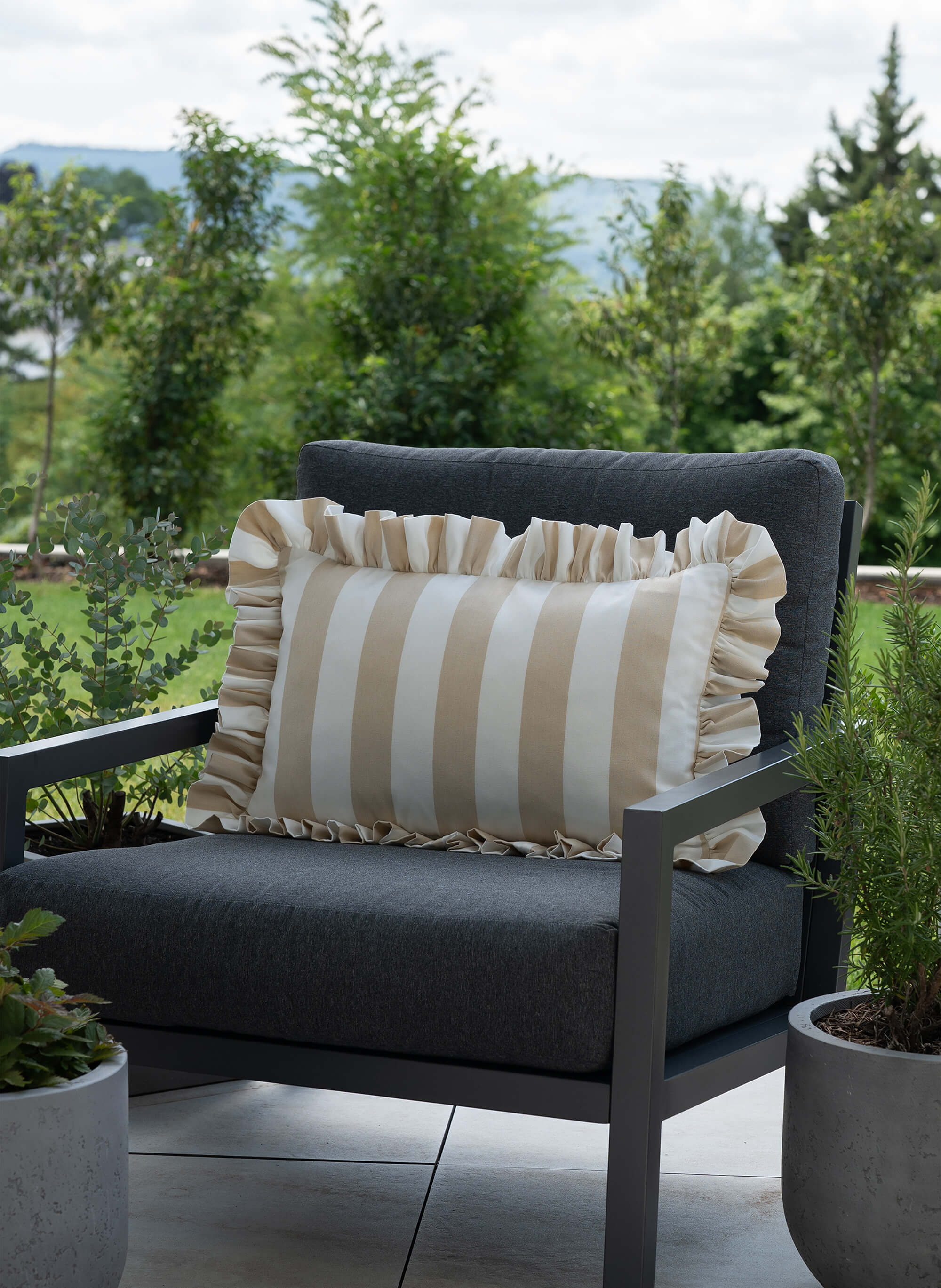 another mondaen Outdoor Kissen Ruffled Charm Erich in Beige auf Gartenlounge – beige-weiß gestreifte Designkissen für Terrasse und Garten aus der VACANCES Outdoor Kollektion