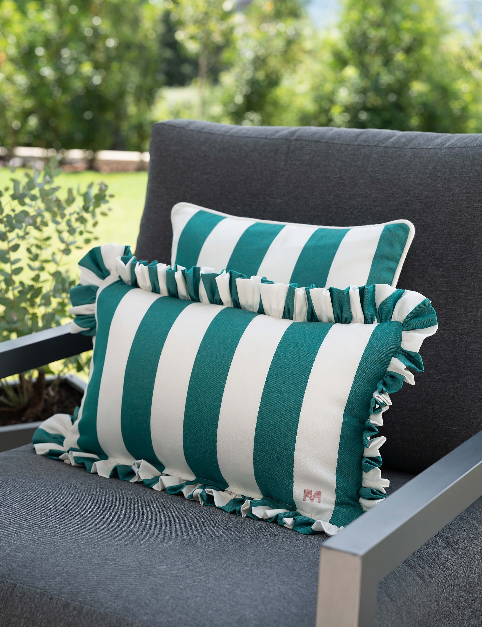 another mondaen Outdoor Kissen Ruffled Charm Forest auf Gartenlounge – grün-weiß gestreifte Designkissen für Terrasse und Garten aus der VACANCES Outdoor Kollektion