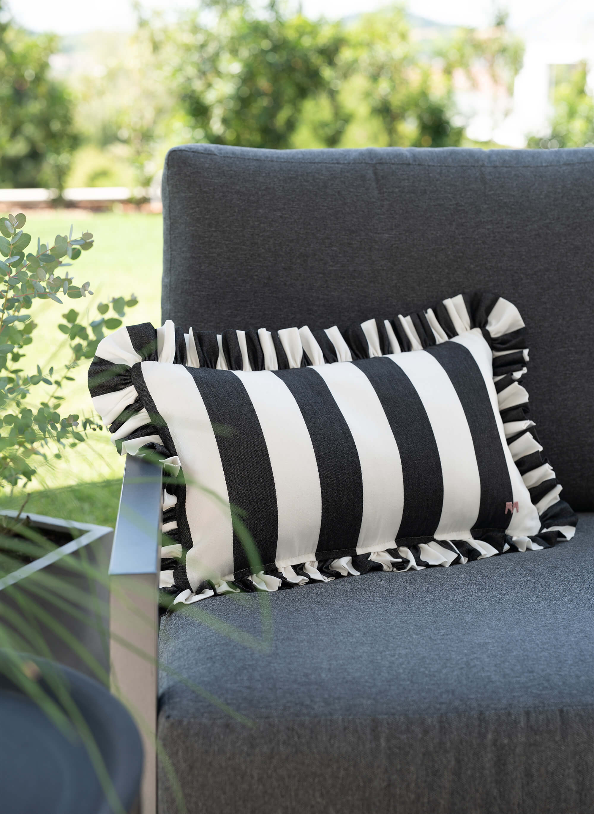 another mondaen Outdoor Kissen Ruffled Charm Graphit auf Gartenlounge – schwarz-weiß gestreifte Designkissen für Terrasse und Garten aus der VACANCES Outdoor Kollektion