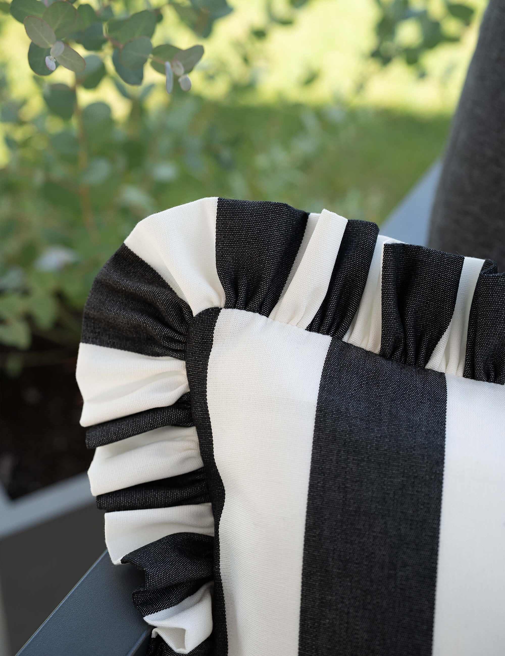 Detailaufnahme des another mondaen Outdoor Kissens Ruffled Charm Graphit – schwarz-weiß gestreifter Outdoor Stoff mit handgefertigter Rüschenkante