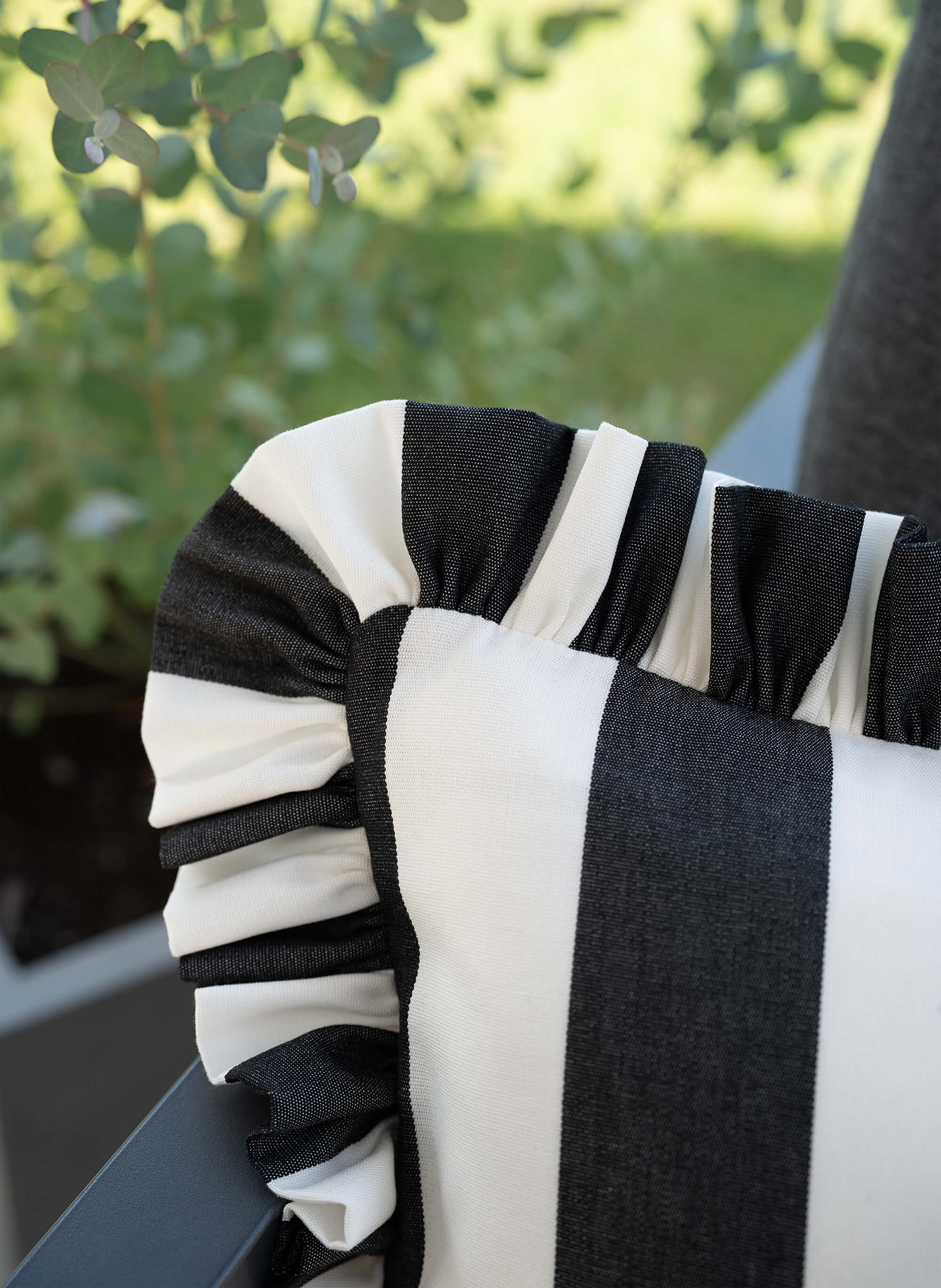 Detailaufnahme des another mondaen Outdoor Kissens Ruffled Charm Graphit – schwarz-weiß gestreifter Outdoor Stoff mit handgefertigter Rüschenkante