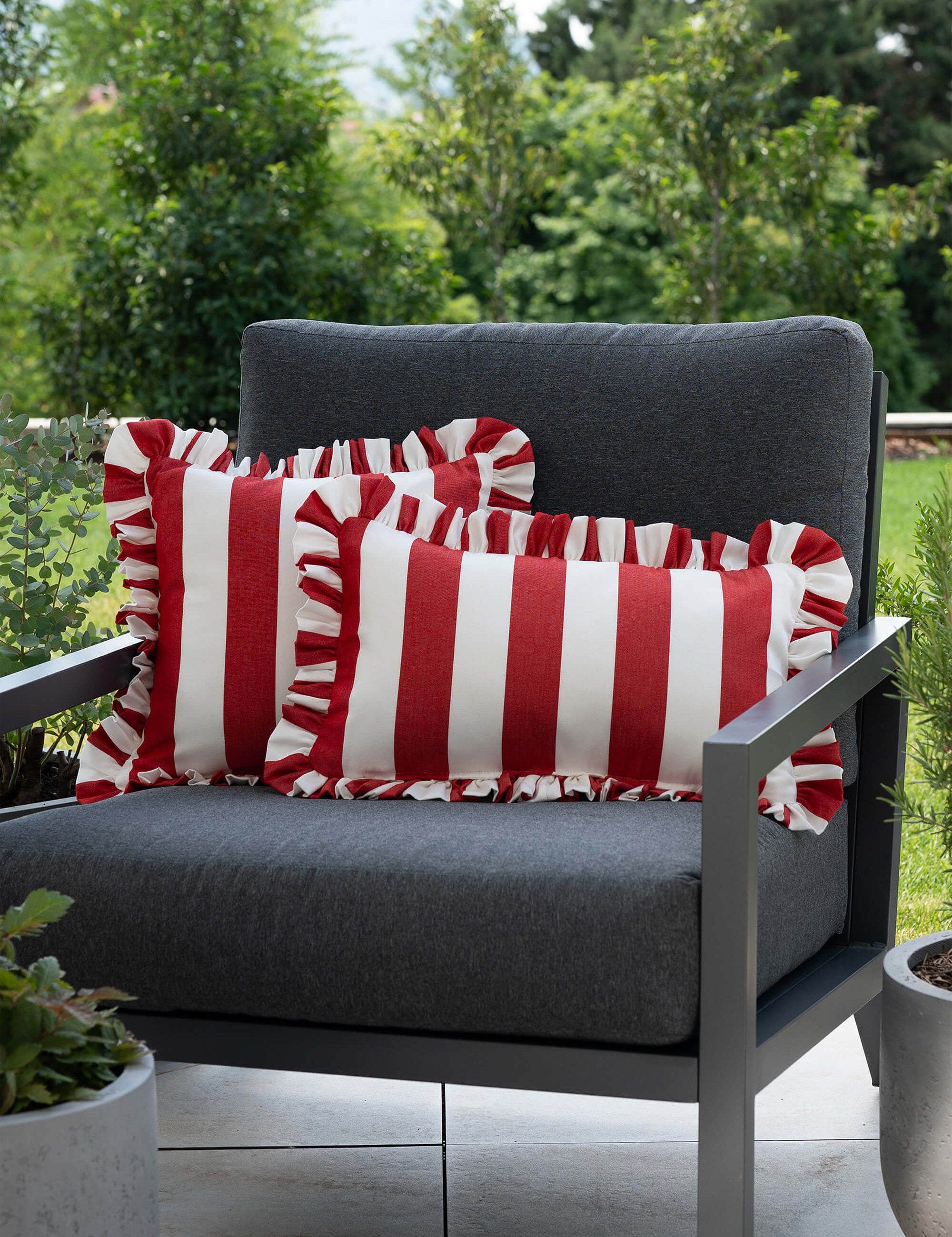 another mondaen Outdoor Kissen Ruffled Charm Red auf Gartenlounge – rot-weiß gestreifte Designkissen für Terrasse und Garten aus der VACANCES Outdoor Kollektion