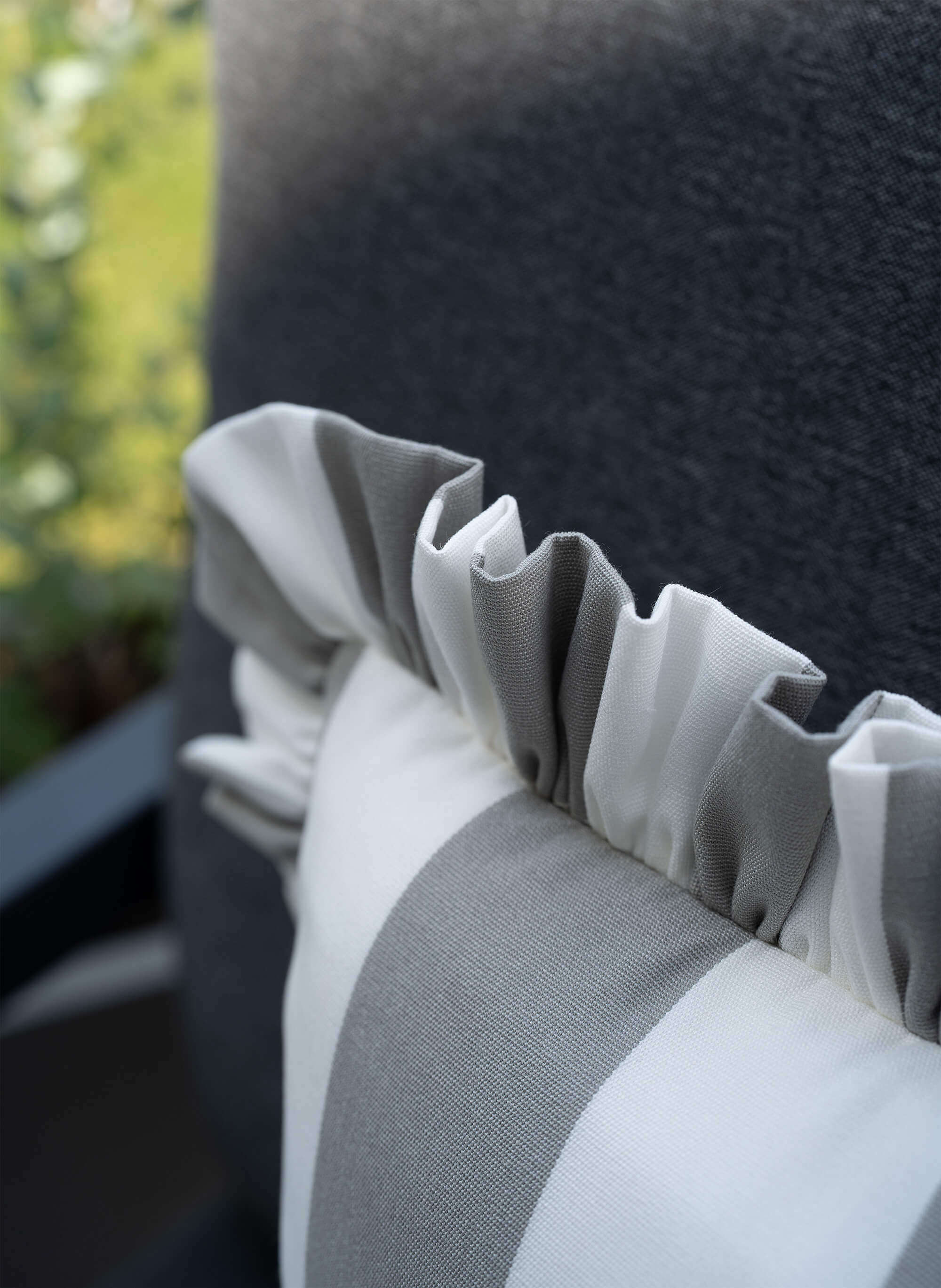 Detailaufnahme des another mondaen Outdoor Kissens Ruffled Charm Stone – grau-weiß gestreifter Outdoor Stoff mit handgefertigter Rüschenkante