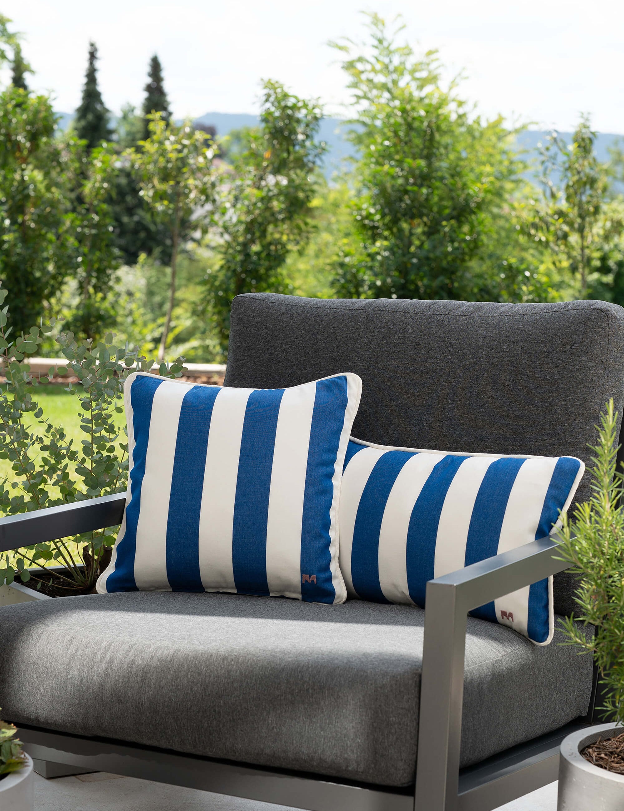 another mondaen Outdoor Kissen Classic Striped Blue auf moderner Gartenlounge – gestreifte Designkissen für Terrasse und Garten