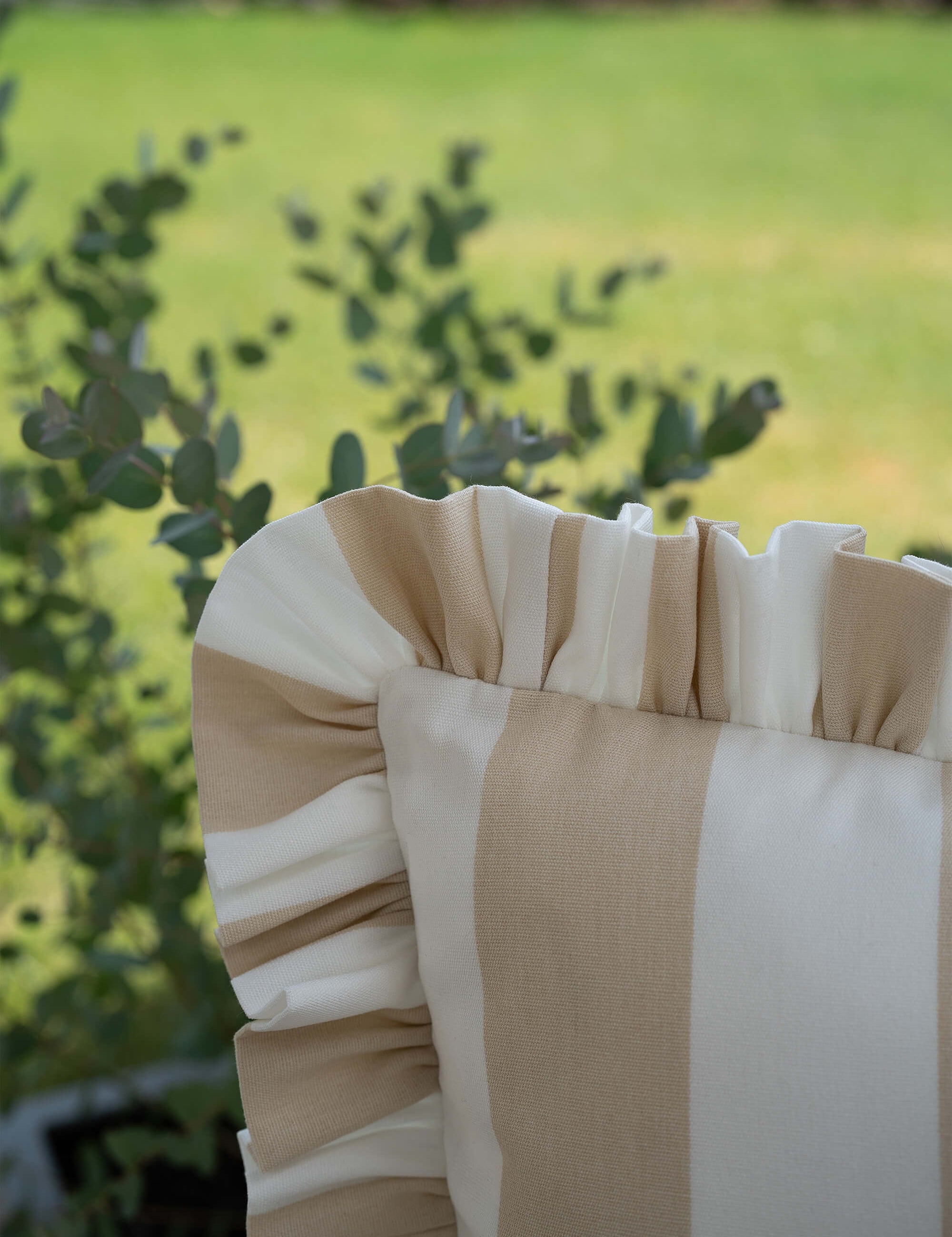 Detailaufnahme des another mondaen Outdoor Kissens Ruffled Charm Beige – beige-weiß gestreifter Outdoor Stoff mit handgefertigter Rüschenkante