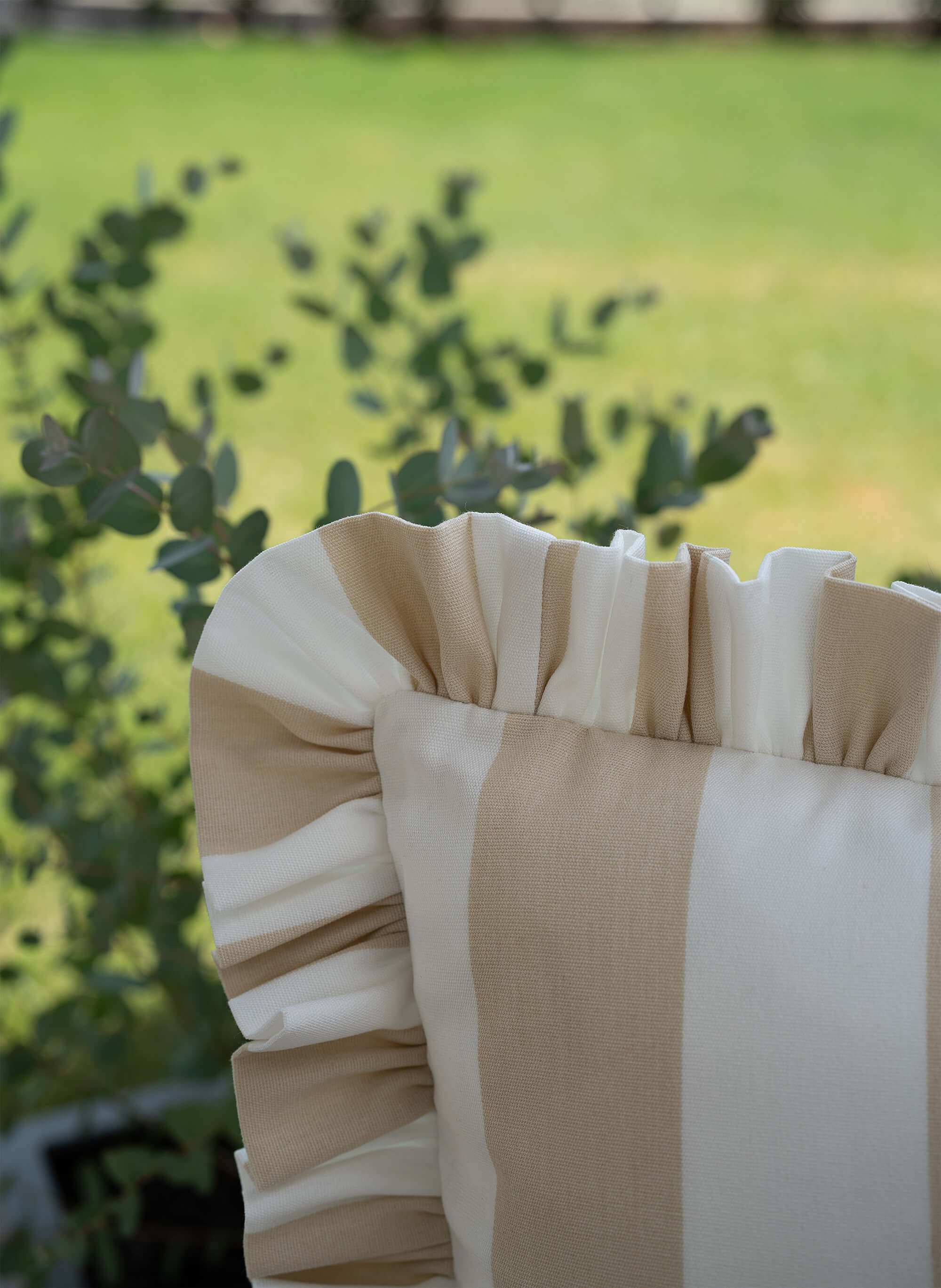 Detailaufnahme des another mondaen Outdoor Kissens Ruffled Charm Beige – beige-weiß gestreifter Outdoor Stoff mit handgefertigter Rüschenkante