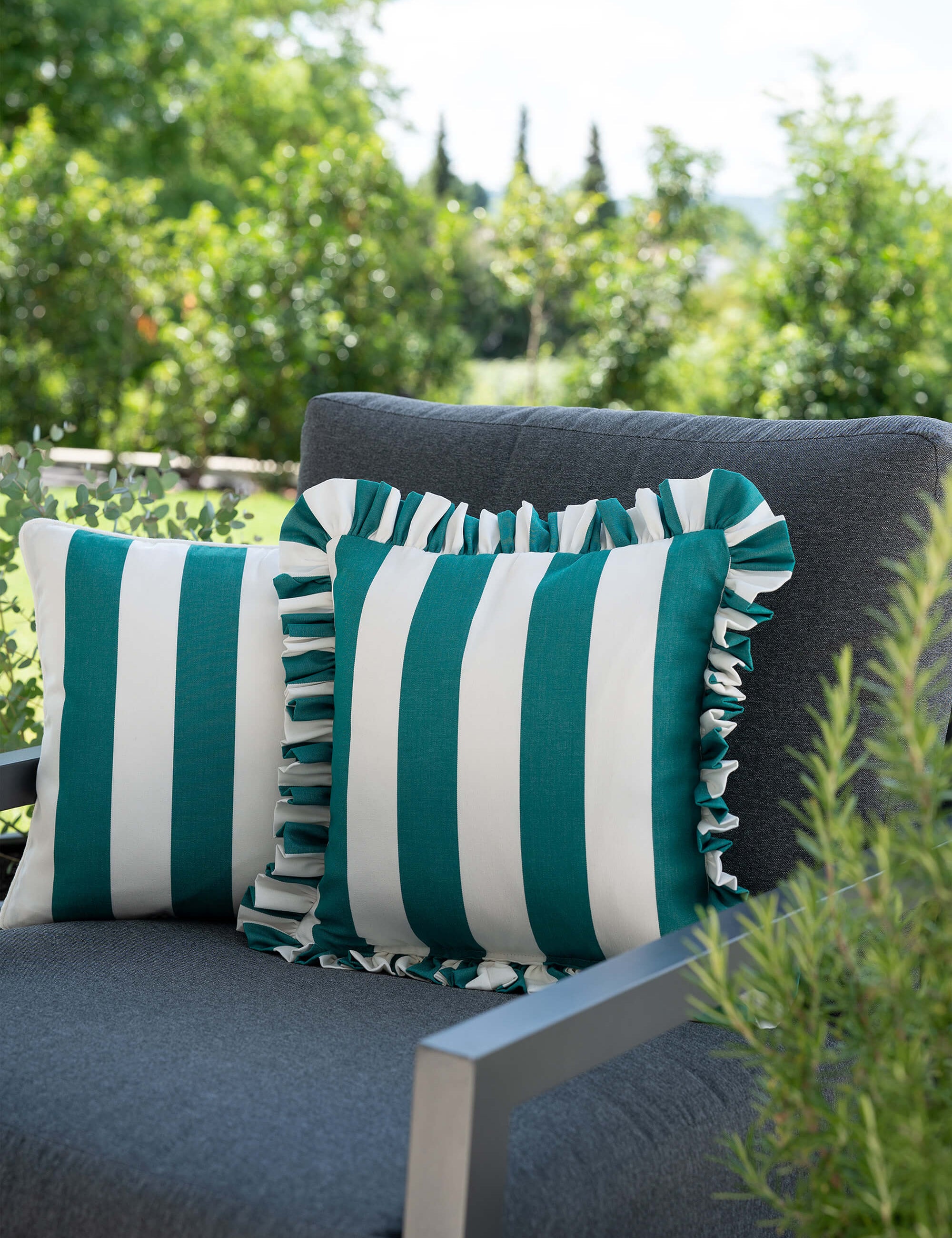 another mondaen Outdoor Kissen Ruffled Charm Forest auf Gartenlounge – grün-weiß gestreifte Designkissen für Terrasse und Garten aus der VACANCES Outdoor Kollektion