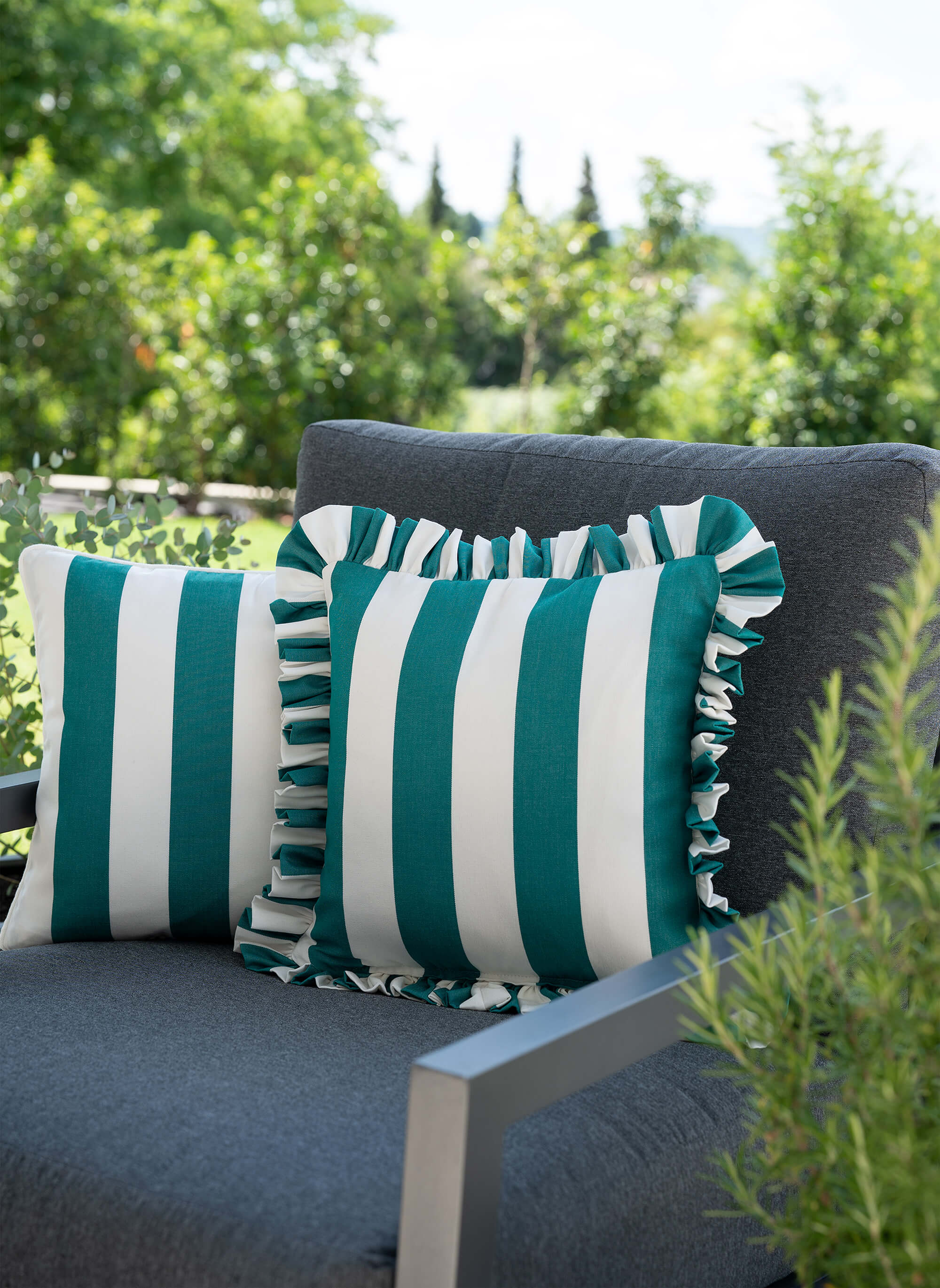 another mondaen Outdoor Kissen Ruffled Charm Forest auf Gartenlounge – grün-weiß gestreifte Designkissen für Terrasse und Garten aus der VACANCES Outdoor Kollektion