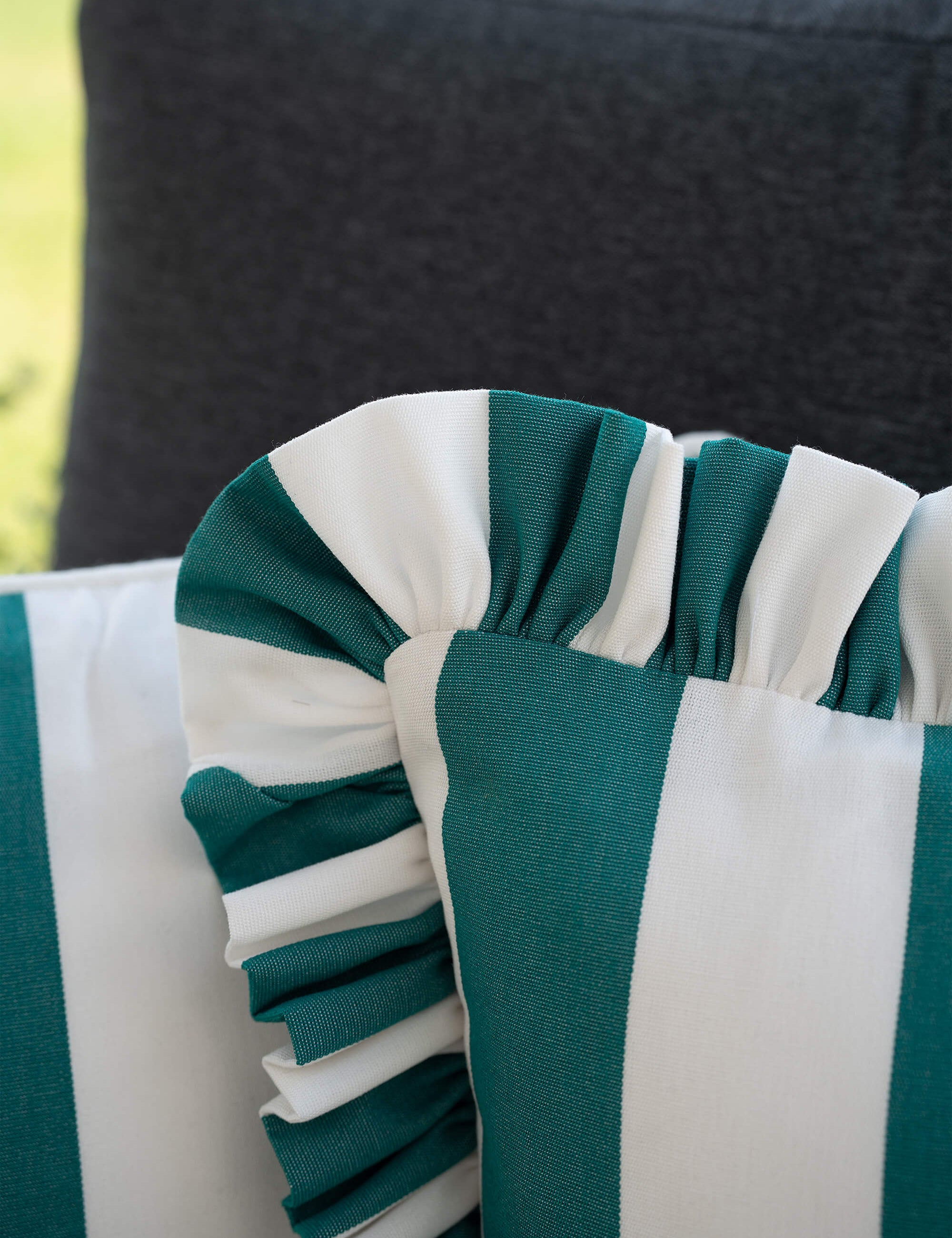 Detailaufnahme des another mondaen Outdoor Kissens Ruffled Charm Forest – grün-weiß gestreifter Outdoor Stoff mit handgefertigter Rüschenkante