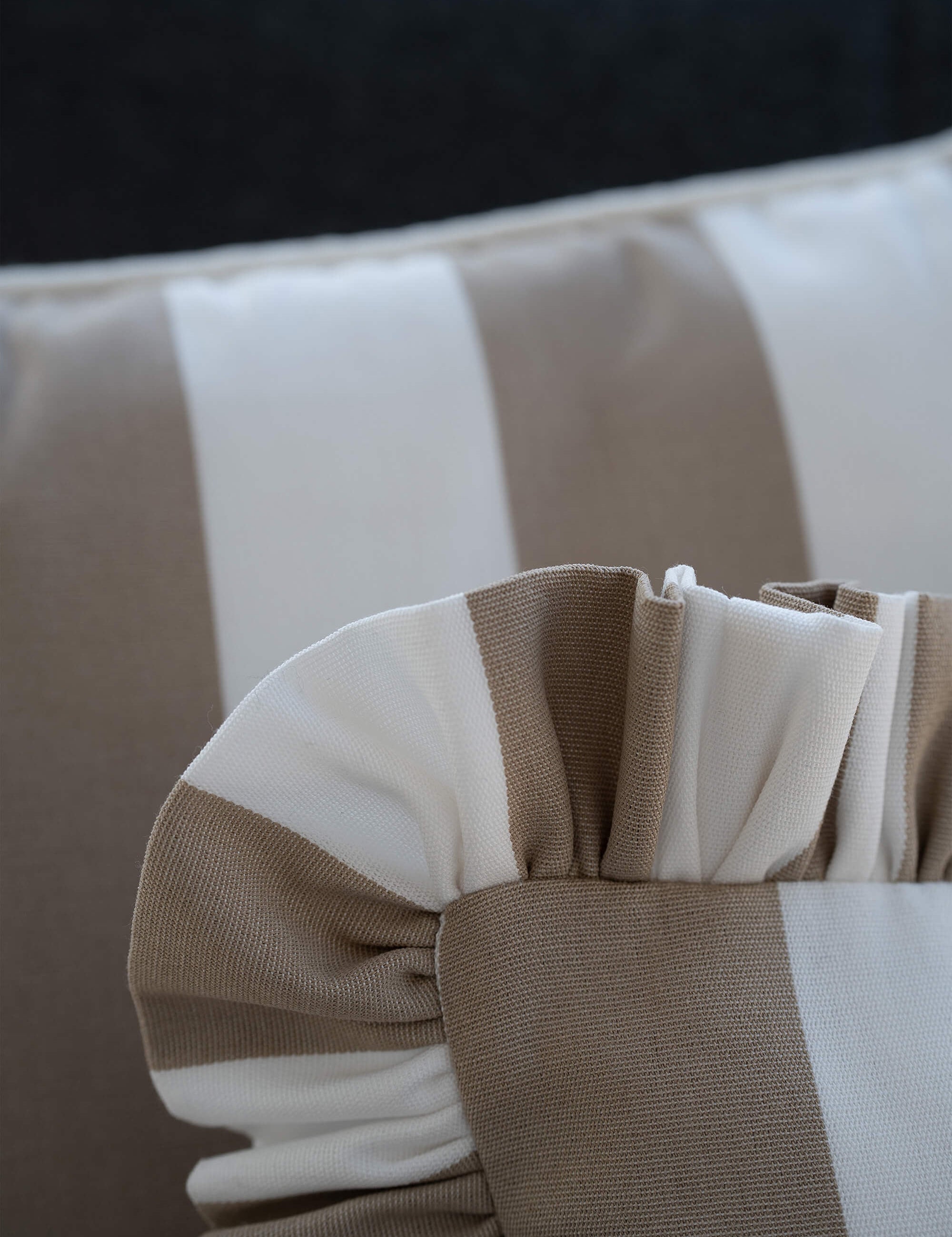 Detailaufnahme des another mondaen Outdoor Kissens Ruffled Charm Taupe – weiß gestreifter Outdoor Stoff mit handgefertigter Rüschenkante
