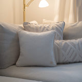 Weißes Uni Kissen in monochromer Interior-Inszenierung, Perspektive von vorne mir warmen leselicht